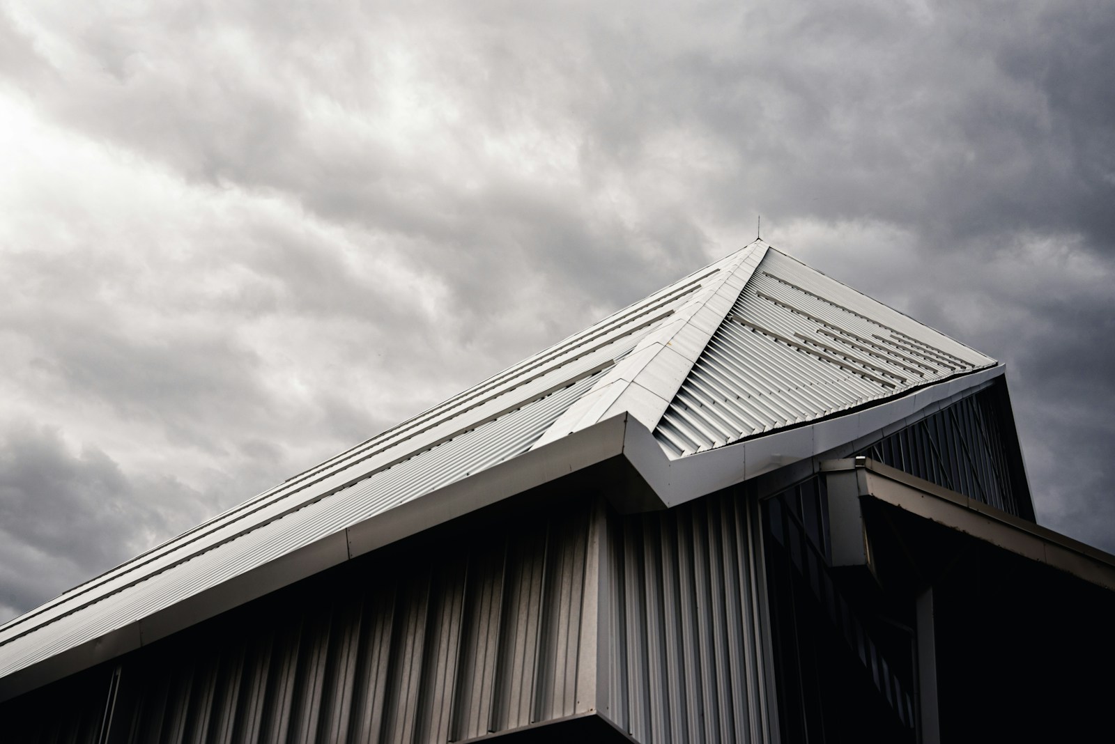 gray and white wooden house under white clouds