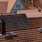 a row of rooftops with a clock tower in the background