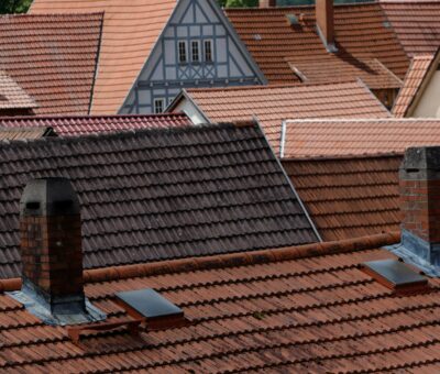 a row of rooftops with a clock tower in the background